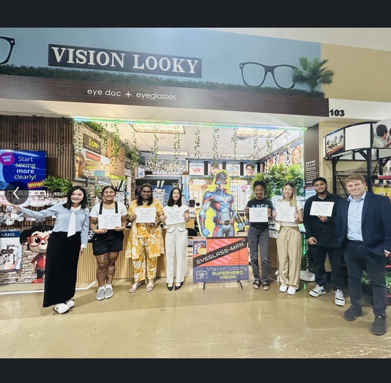 Two interns displaying their Vision Looky Studio completion certificates.